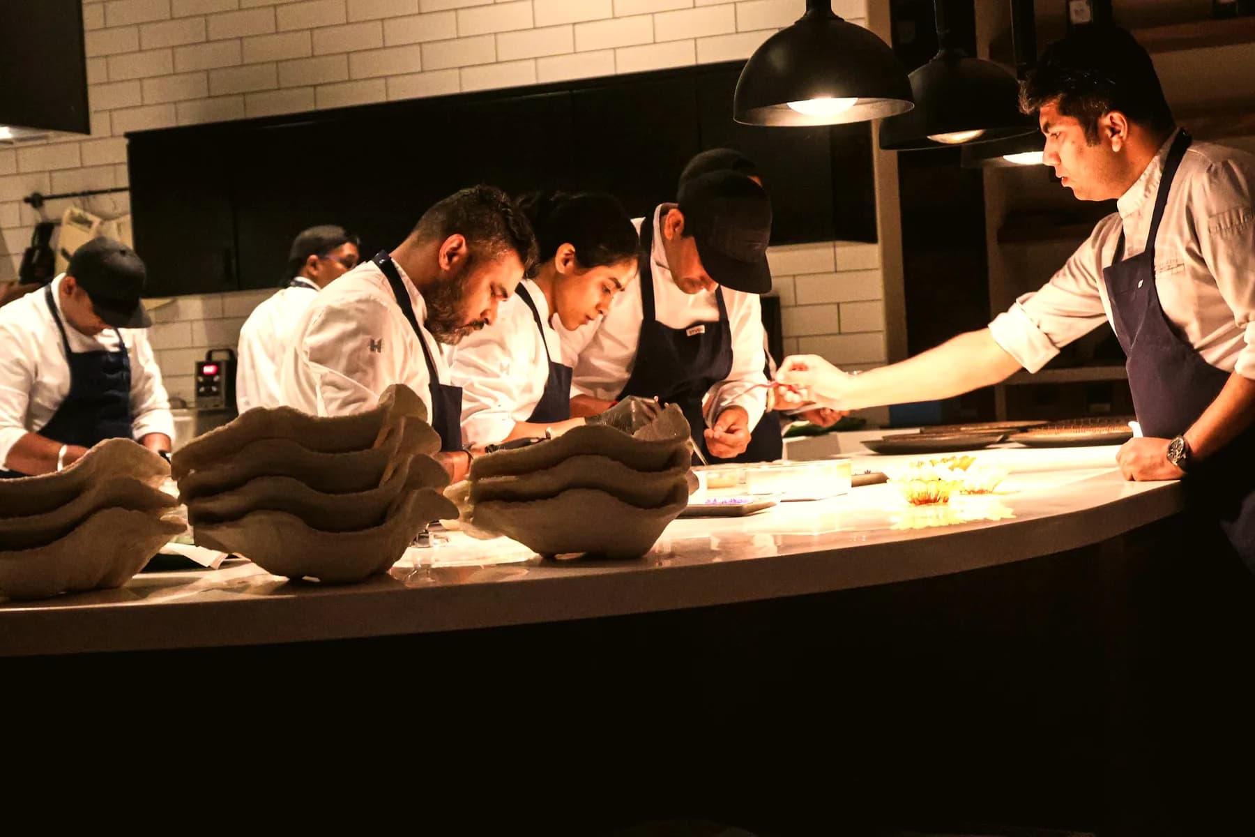 Chefs preparing orders in a busy open kitchen